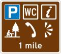 Britisches Schild, das auf einen Rastplatz mit Parkplätzen, WC, Infopunkt, Picknicktisch, Telefon und Aussichtspunkt hinweist