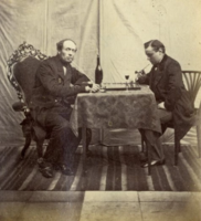 1863-1864: Zelfportret van J.E. van Rheden, hoofdonderwijzer te Wijk bij Duurstede, schakende met een hulpdocent. De oudste schaakgerelateerde foto van Nederland en mogelijk de oudste schaakgerelateerde 3D-foto ter wereld.