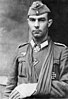 Black and white portrait of a man with his left arm in a sling and wearing a military uniform