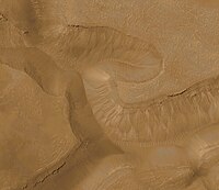 Imagem colorida de ravinas na parede do conjunto de cânions Gorgonum Chaos, na região do Quadrângulo de Phaethontis. Imagem fotografada pela Mars Global Surveyor.