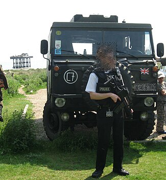 Trots den civila traditionen kan en brittisk polis se militärisk ut. Polisman från den civila kärnkraftspolisen med skyddsväst och automatkarbin.