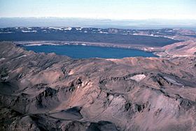 Vue aérienne d'une partie des Dyngjufjöll au premier et dernier plans avec la caldeira d'Askja partiellement remplie par l'Öskjuvatn.