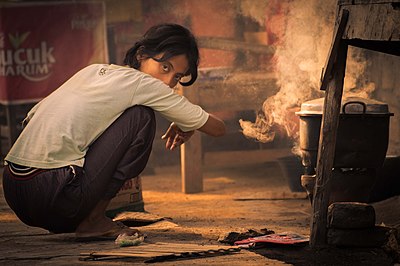 Seorang anak perempuan di Bantul, Yogyakarta, sedang memasak nasi dengan bantuan tungku