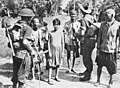 Image 89Australian soldiers and local civilians on Labuan Island. The soldier on the left is armed with an Australian-designed Owen gun. (from Military history of Australia during World War II)