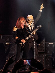 Vic na pódiu během koncertu, vedle něj Dave Mustaine