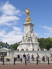 Bronze statue of winged victory mounted on a marble four-sided base with a marble figure on each side