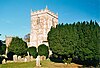 A short, square tower, with gravestones near its base