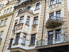 Vue rapprochée d'une façade art nouveau, des bow-windows saillants et des balcons triangulaires sont visibles.