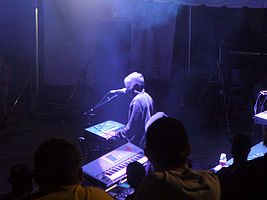 A man with electronic musical instruments performing at an annual electronic dance music event