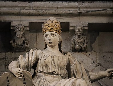 Baroque sculpture and earlier modillons behind her in the choir