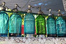 A row of colorful soda siphons on a shelf