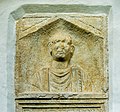 English: Alcove portrait of the 30 year old soldier Aurelius Secundianus at an ancient Roman sepulchral stele (CSIR II/2, 138) on the south wall Deutsch: Nischenporträt des dreißigjährigen Soldaten Aurelius Secundianus an der römerzeitlichen Grabstele (CSIR II/2, 138) an der S-Wand