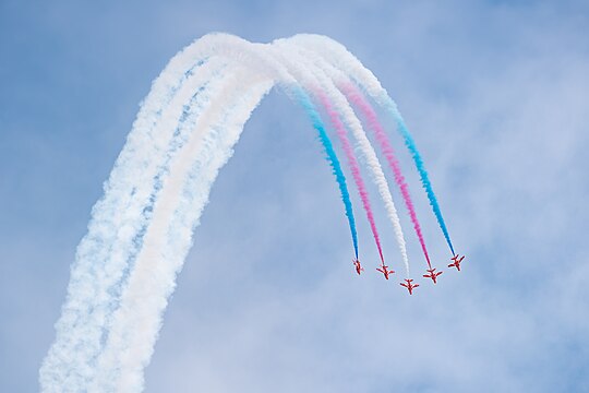 Red Arrows in formation flight as part of the "vertical break" display element at the Royal International Air Tattoo 2023.