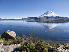 Blue lake with white conical mountain in the background