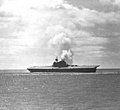 The Yorktown lists heavily to the port side with smoke billowing from her single funnel after an attack by Japanese aircraft 4 June 1942