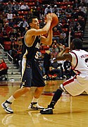 US Navy 071217-N-7206K-004 U.S. Navy Midshipman Chris Harris looks for an opening to pass the ball to his teammates during a basketball game against the San Diego State University Aztecs.jpg