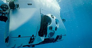 Underwater view of the Limiting Factor floating at the surface from off the starboard bow