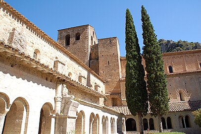 La galerie ouest avec un vestige du pavillon du lavabo, la galerie nord contre l'abbatiale, la tour Saint-Martin et le clocher.