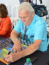 Bill Simpson signing an autograph on a table