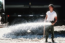 PH1 Ted Salois Tinian, Marianas Islands....Constructionman Steve Baum of Naval Mobile Construction Battalion 3 (NMCB-3) hoses down crushed stone while working on a roadway project i - DPLA - e56ca507ae01443e732ffe36fa91b310.jpeg