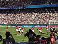 A soccer game between the United States and Canada, seen from behind one of the goals. (from Women's association football)