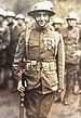 Three-quarters frontal picture of a man in uniform wearing a metal helmet with 2nd Infantry Division insignia. The Medal of Honor, French Croix de guerre with two bronze palms and one silver star and Montenegrin Medal for Military Bravery are pinned to his uniform coat.