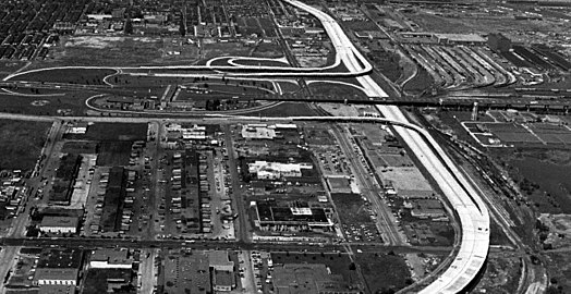 Zufahrt zur Brücke in South Philadelphia (von links nach rechts, I-76) mit Mautstation im Zentrum des Autobahn­dreiecks, von oben nach unten verläuft die I-95 (1975)