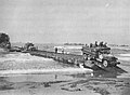 1006th Seabees in the Salerno Invasion,Operation Avalanche, unloading an LST ship over a Pontoon Causeway at Safta Beach in September 1943. The ship had trained and loaded with the Pontoon Causeway at an US Naval Bases North Africa Amphibious Training Bases