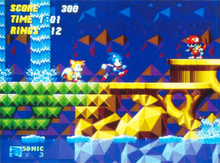 Sonic runs through ancient ruins with an emerald-colored bridge and golden platforms. Waterfalls flow behind him, water sits beneath him, Tails stands behind him, and a dinosaur robot walks in front of him.