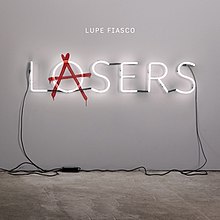 Image of a gallery setting, where a LOSERS sign is plugged into the wall. Superimposed over the 'O' is the red anarchist 'A' to read LASERS.