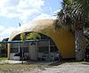 One of the two "Bubble Houses" in Hobe Sound, Florida, behind a palm tree.