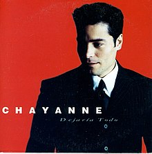 Image of Chayanne wearing a suit and tie looking left with a red background