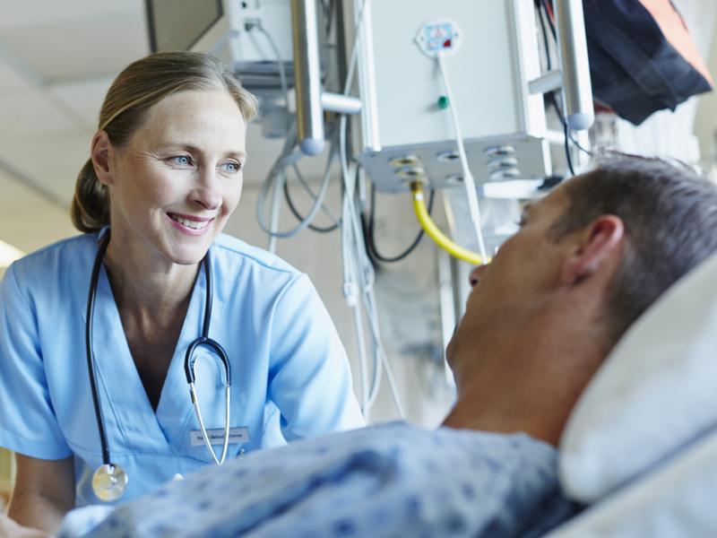 Physician checking in on patient in bed