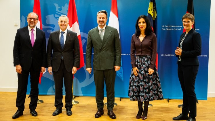 Der österreichische Außenminister Alexander Schallenberg, der Schweizer Außenminister Ignazio Cassis, der Luxemburger Außenminister Xavier Bettel, die Liechtensteiner Außenministerin Dominique Hasler und die deutsche Staatssekretärin Anna Lührmann posieren für ein Foto vor ihren jeweiligen Landesflaggen.