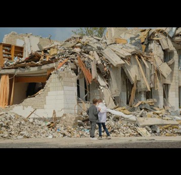 Two boys walking at destroyed school in the Ukrainian city of Zhytomyr after a Russian ballistic missile hit.