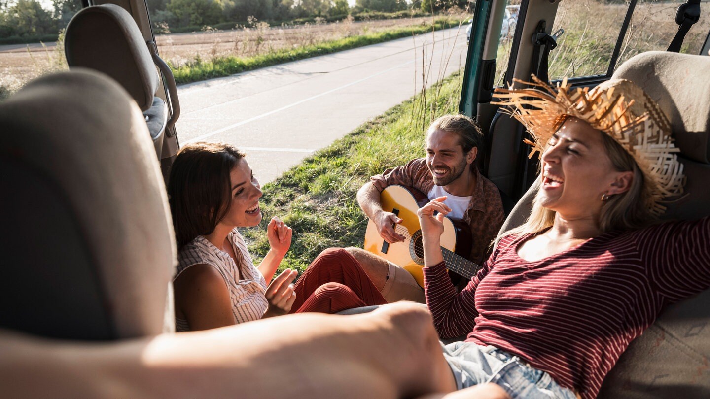 Eine Gruppe sitzt glücklich miteinander in einem Bus.