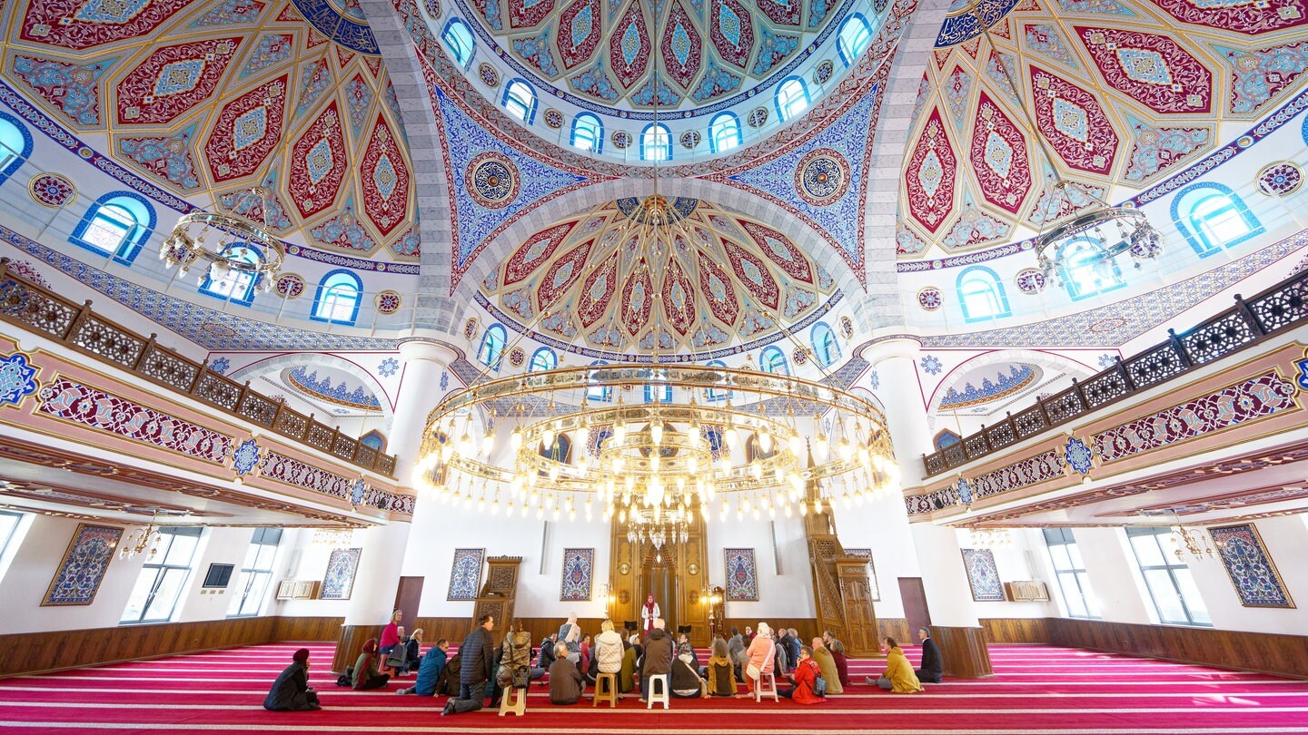 Besucher sitzen bei einer Führung in der DITIB-Merkez Moschee in Duisburg - Über 40 Verletzte durch islamfeindliche Straftaten in 2024