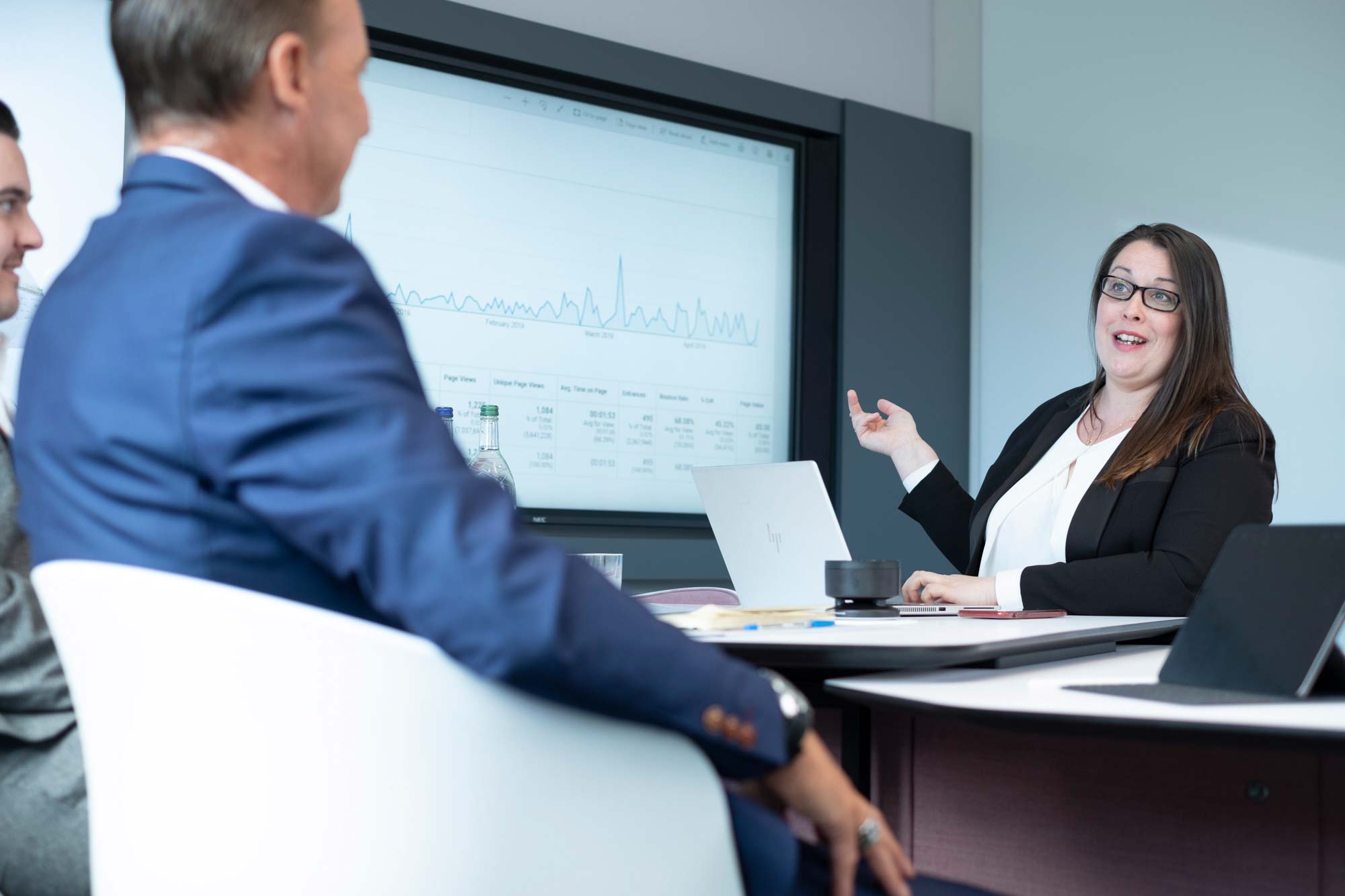 Female showing male colleagues analytics on a big screen