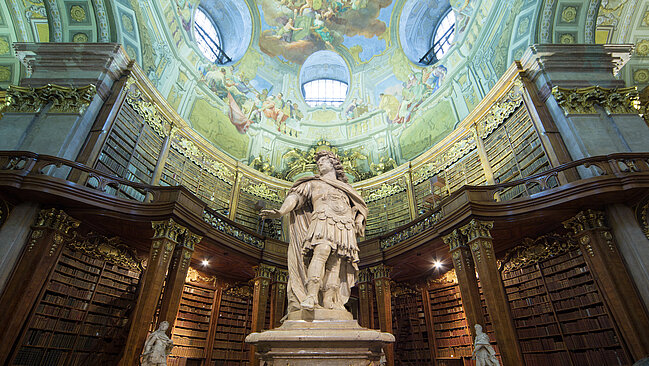 Statue von Karl VI. im Zentrum eines barocken Bibliothekssaal