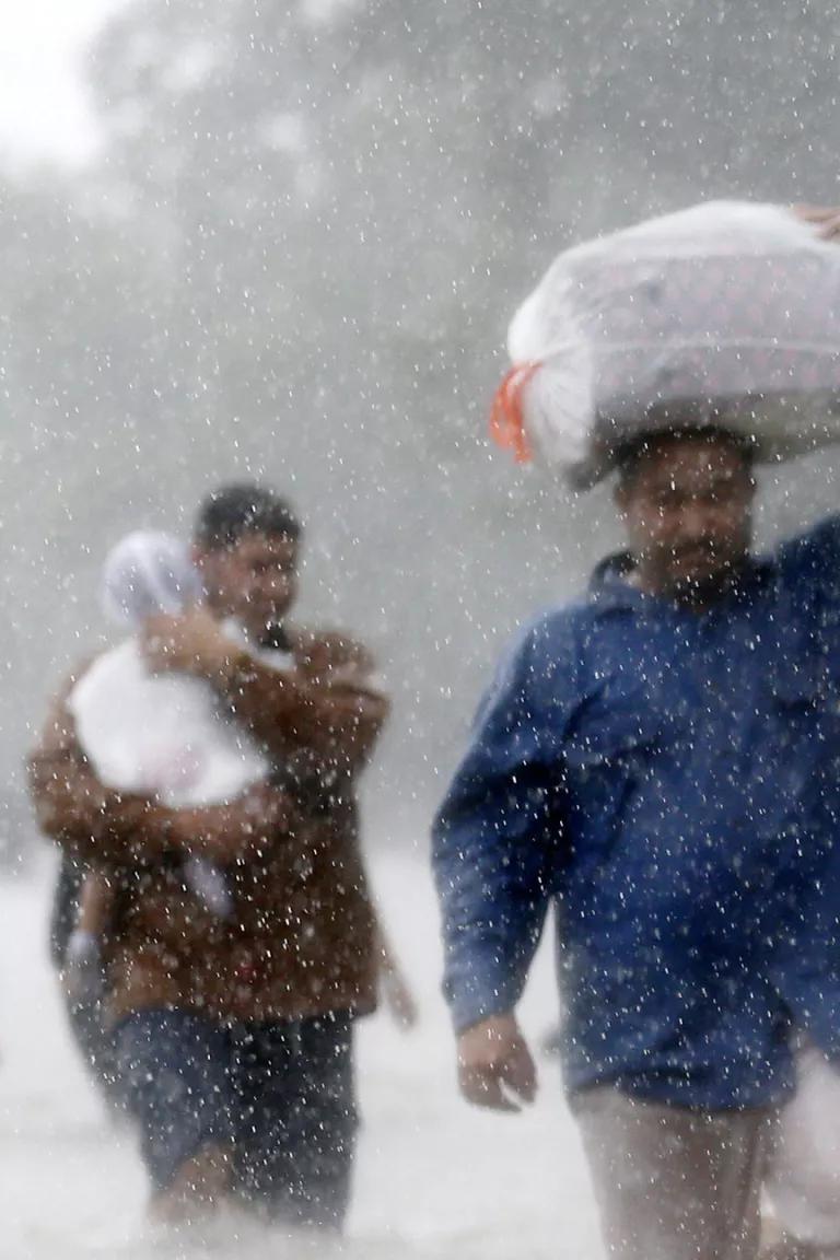 A blurry image of a line of people wading through floodwaters from Tropical Storm Harvey in Beaumont Place, Houston, Texas, 2017