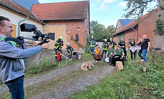 Beste Stimmung und Klamauk beim Videodreh: Der Spielmannszug, die Feuerwehr und der Metal Bus teilen sich eine Szene im Musikvideo und mimen eine illustre Runde am Lagerfeuer. Daniel Winkler filmt. - Madita Schellenberg