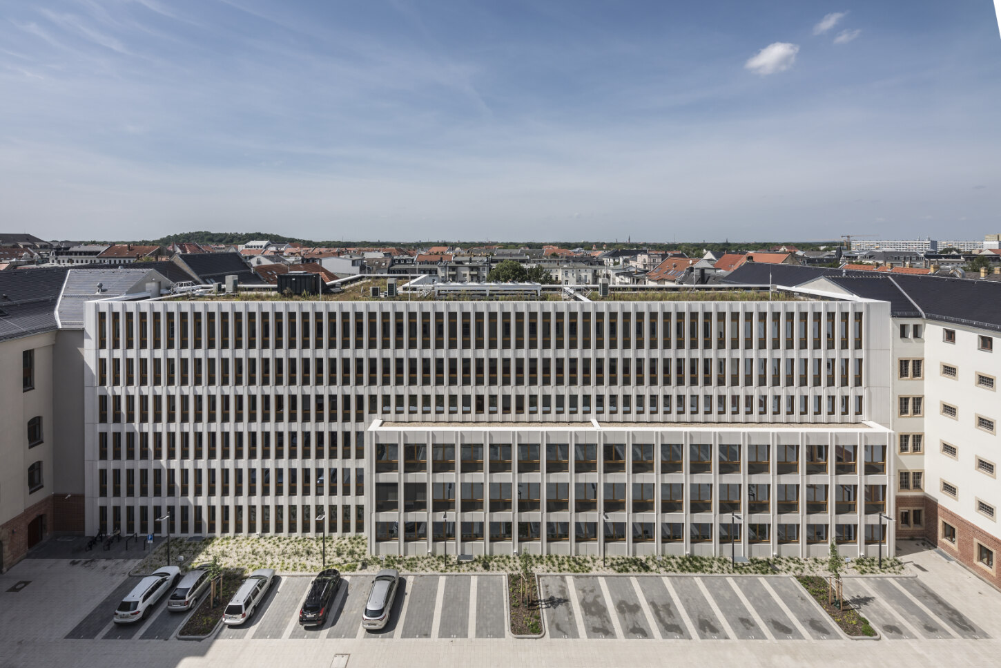 Es ist ein langgestrecktes Gebäude mit viel Fensterfläche und einer hellen Fassade.