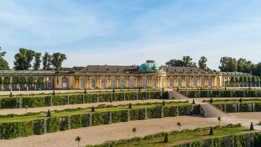 Blick auf das Schloss Sanssouci im Sonnenschein, im Vordergrund die Terrassen