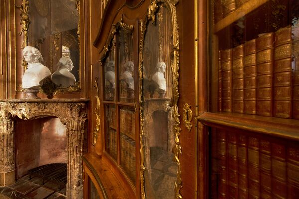 Bibliothek Friedrich II. im Schloss Sanssouci, der Blick entlang eines der Buecherschraeke, mit dem Kamin und der Bueste Friedrich des Großen von Cavaceppi im Hintergrund