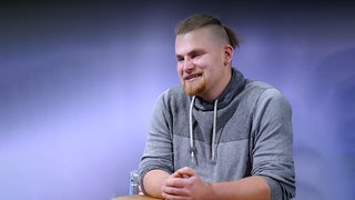 Hobby Köhler Max mit einem Man-Bun im Studio