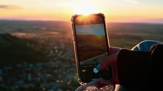 Smartphone fotografiert Landschaft. Wohin beim nächsten Ausflug? Baden-Württemberg und Rheinland-Pfalz haben viele Ausflugsziele in der Nähe zu bieten. Seen, ein Schloß oder eine Höhle lohnen sich besonders mit Kindern.