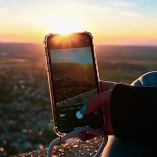 Smartphone fotografiert Landschaft. Wohin beim nächsten Ausflug? Baden-Württemberg und Rheinland-Pfalz haben viele Ausflugsziele in der Nähe zu bieten. Seen, ein Schloß oder eine Höhle lohnen sich besonders mit Kindern.