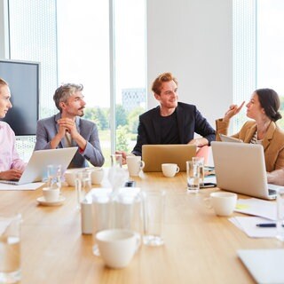 Eine Gruppe von Menschen unterhält sich in einem Meetingraum. In SWR1 Leute spricht Michael Hans Hahl über Tipps zur besseren Kommunikation.