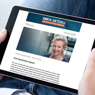 Ein Leser betrachtet den SWR Aktuell Newsletter auf dem Tablet; im Editorial: Evi Seibert, Studioleiterin SWR Hauptstadtstudio Berlin 