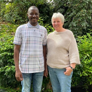 Francis Ssentumbwe und Ursula Heinemann stehen in deren Garten in Kusterdingen-Mähringen. Sie hatten gemeinsam die Idee für ein inklusives Schulprojekt in Uganda.